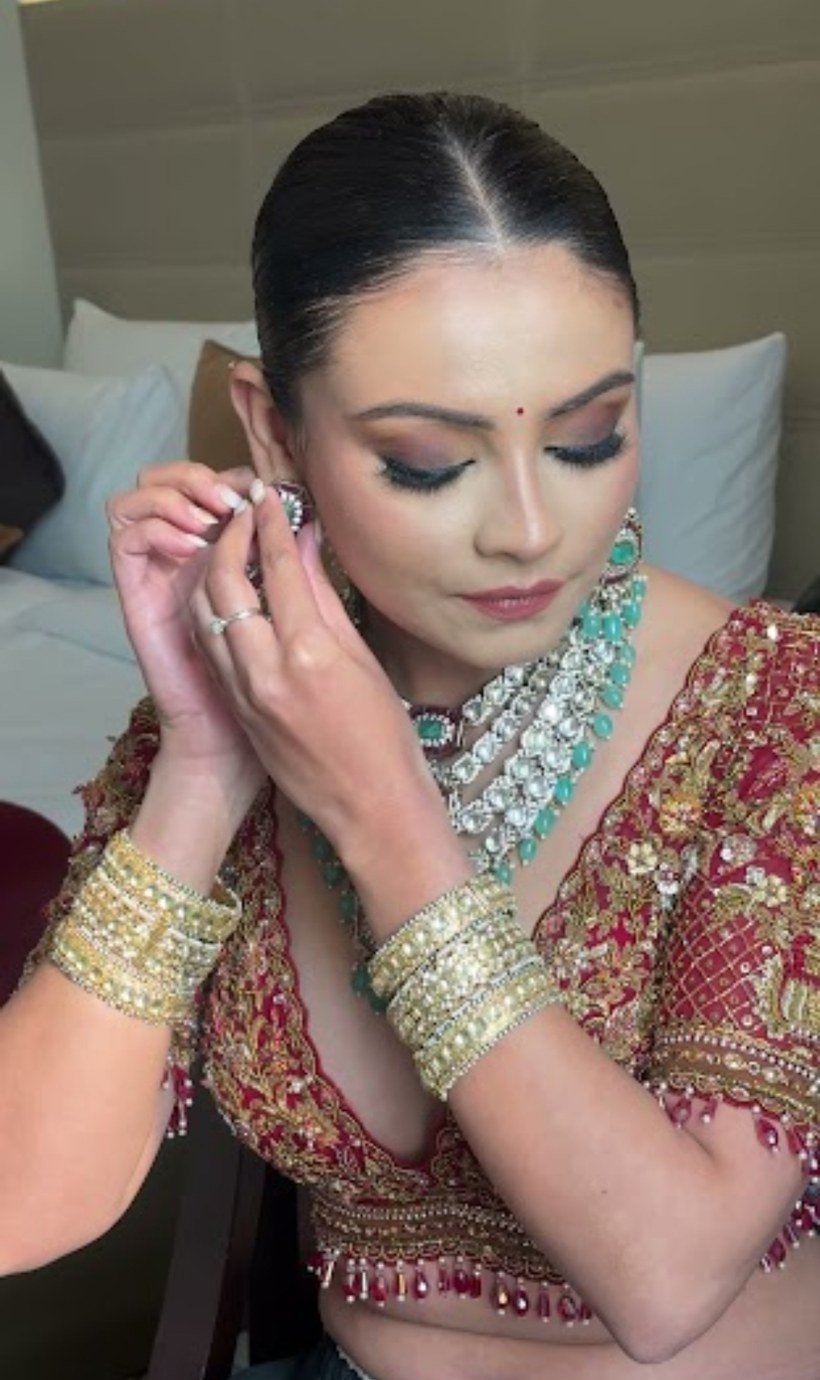 Bridal getting ready — bride putting on earrings, red outfit with turquoise jewelry